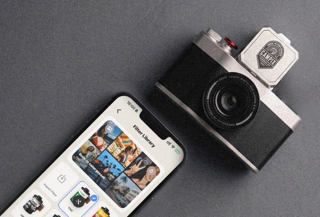Fotorgear Campix junto a un móvil con la biblioteca de filtros de la app abierta