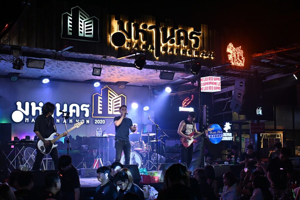Banda tocando en directo con focos de colores y el público delante del escenario