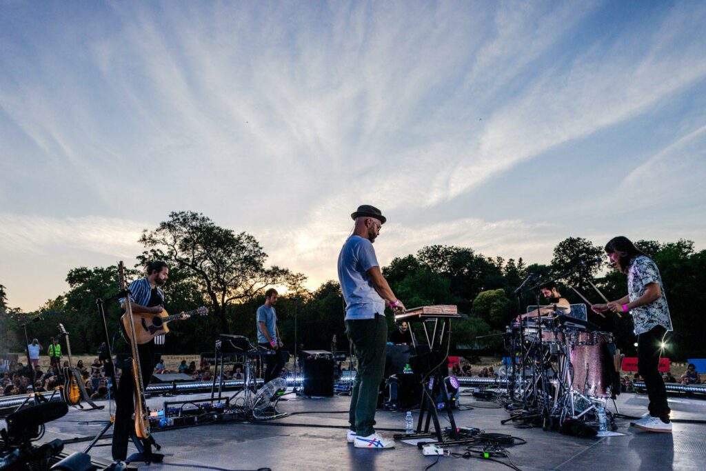 Vetusta Morla en directo en un escenario al aire libre al atardecer